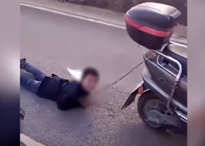Como castigo por travieso, mujer amarra a su hijo a motocicleta para arrastrarlo. Foto: Youtube / RT en español